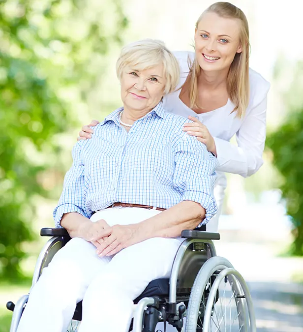 an old lady sitting on wheelchair and behind her a girl standing