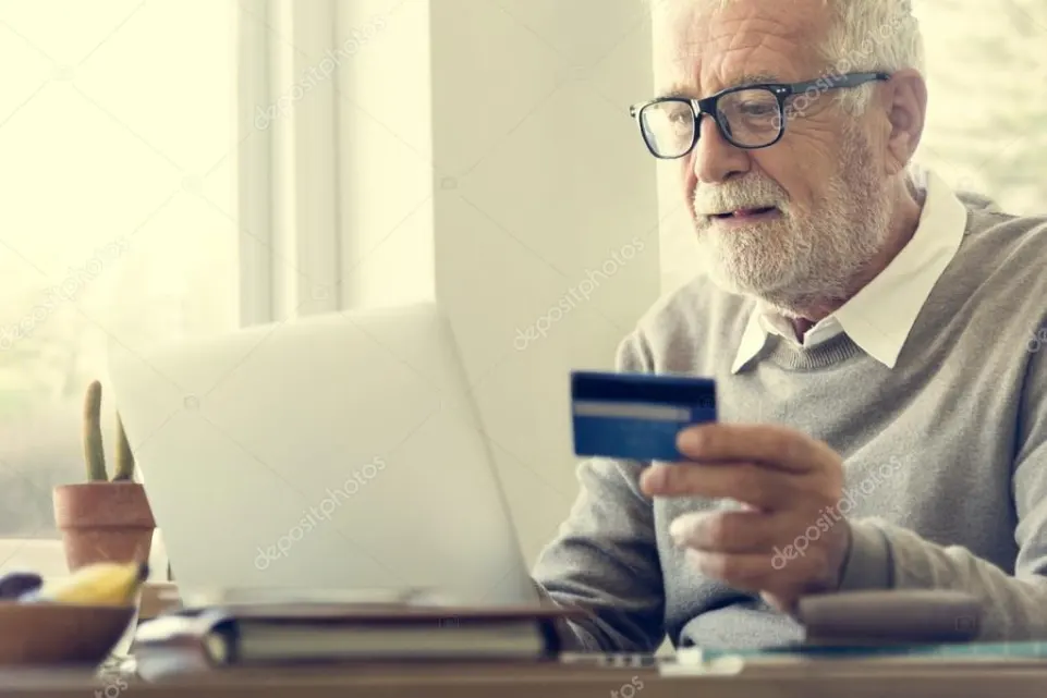 an old man enter card details on their laptop