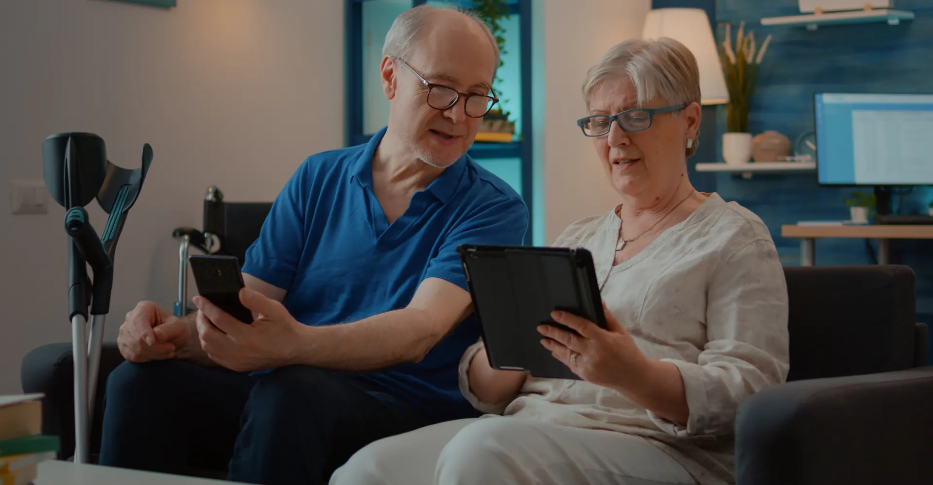 an old man using phone and an old lady using tablet