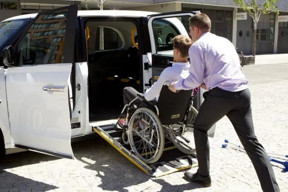 care taker help disbale man to enter in van