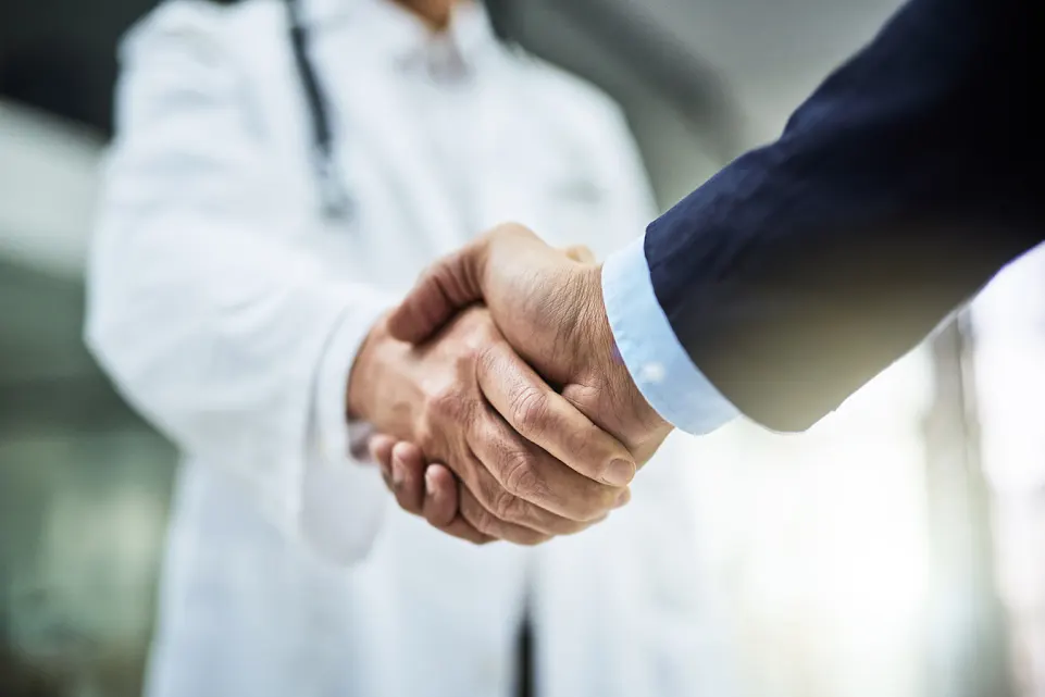 the doctor and client shake hand